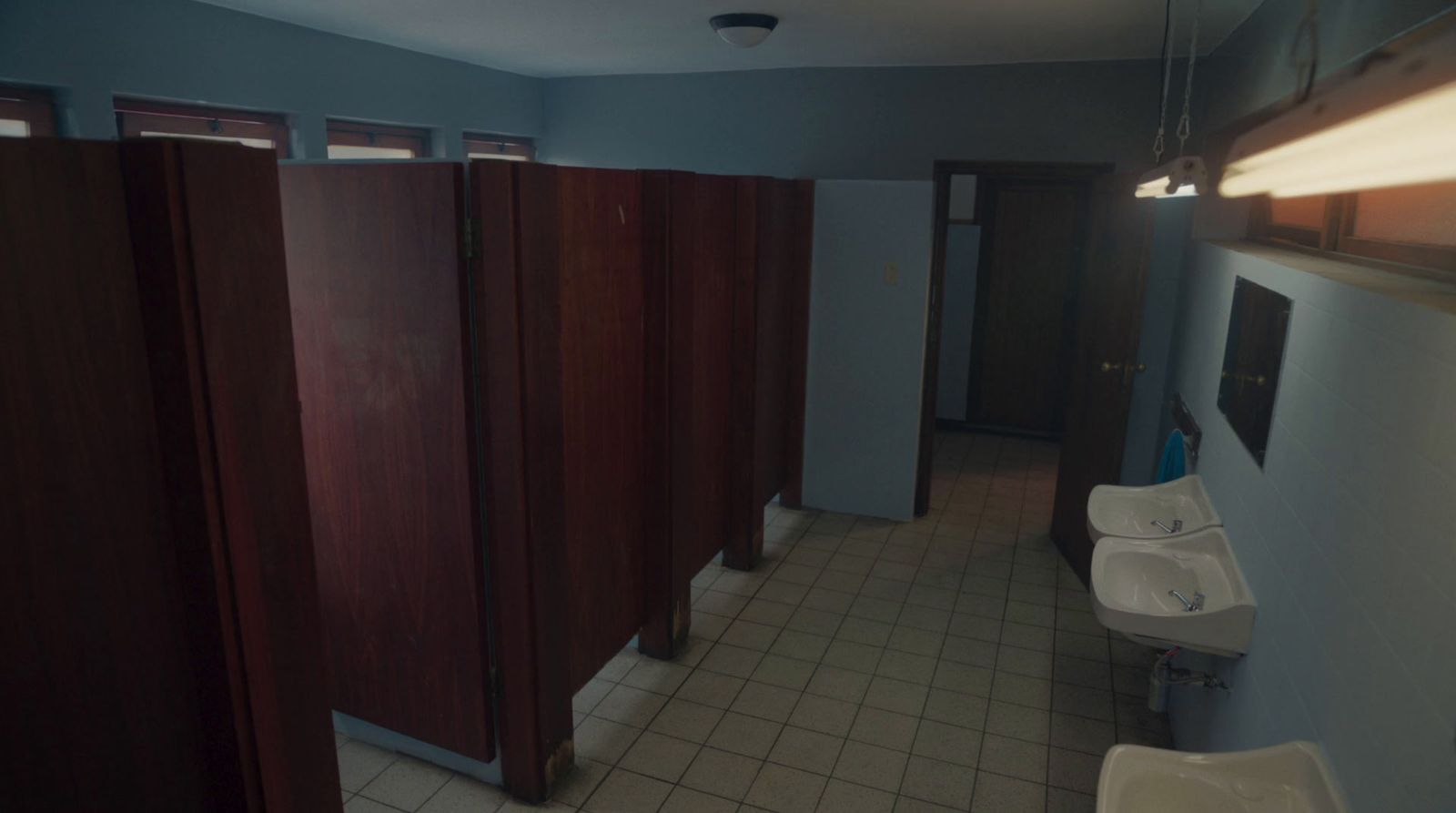 a bathroom with several stalls and a sink