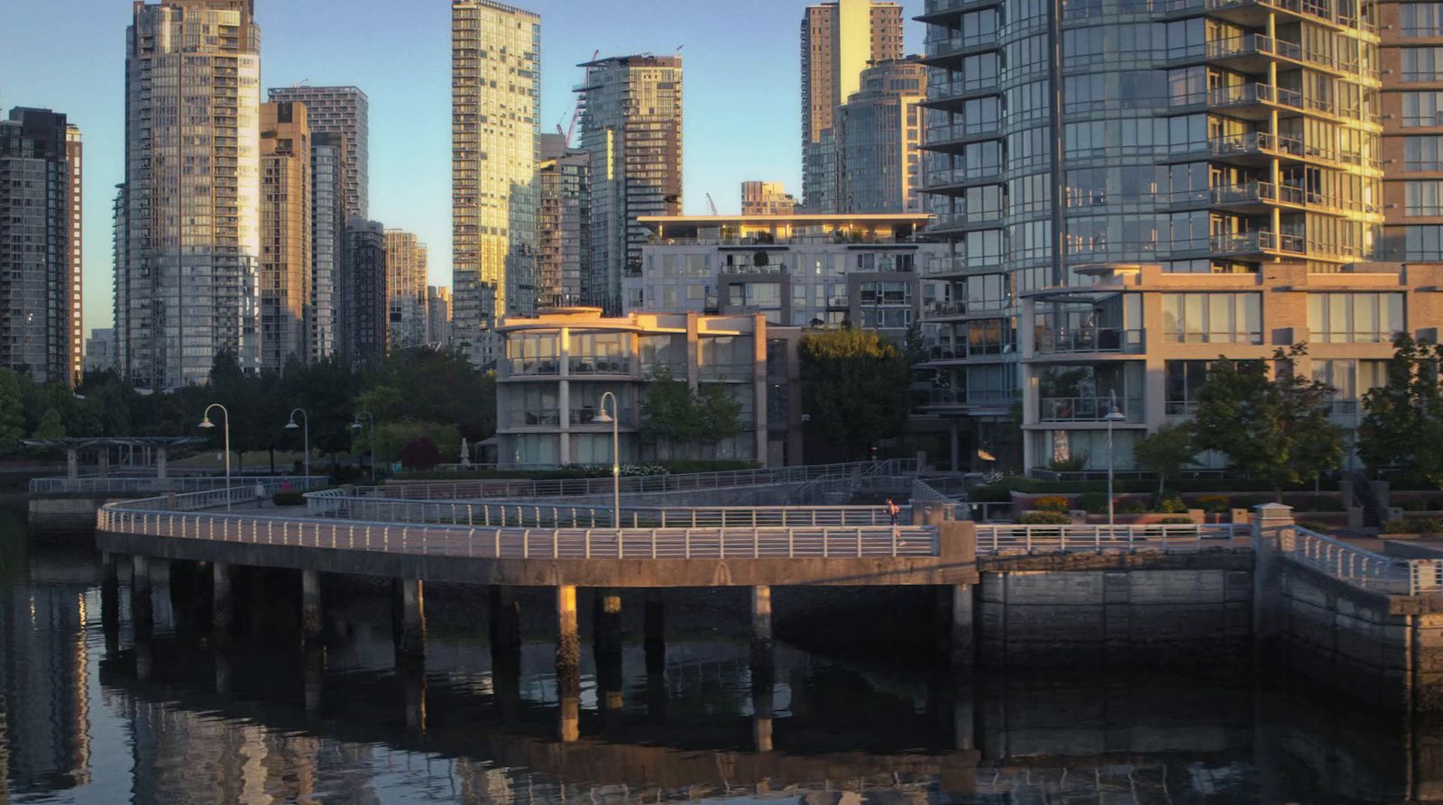 a bridge over a body of water in front of tall buildings