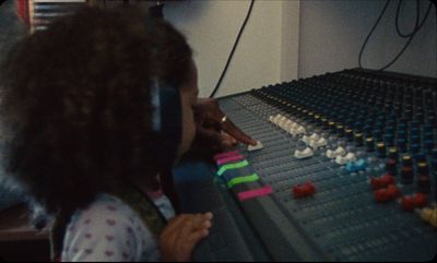 a little girl wearing headphones playing a sound board