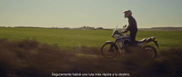 a man riding a motorcycle on a lush green field