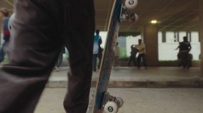 a person holding a skateboard in a parking garage