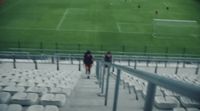 two people walking up a set of stairs in a stadium