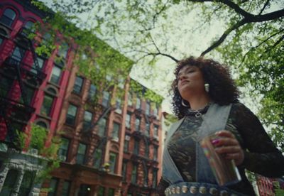 a woman standing in front of a tall building