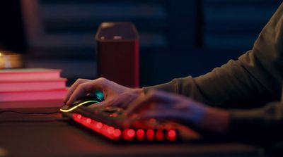 a person is typing on a keyboard with red lights