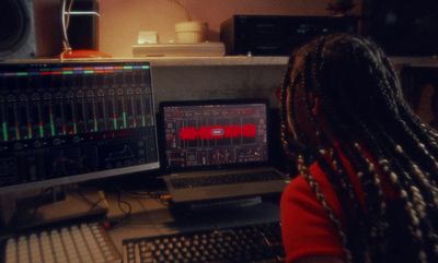 a woman sitting in front of a computer monitor