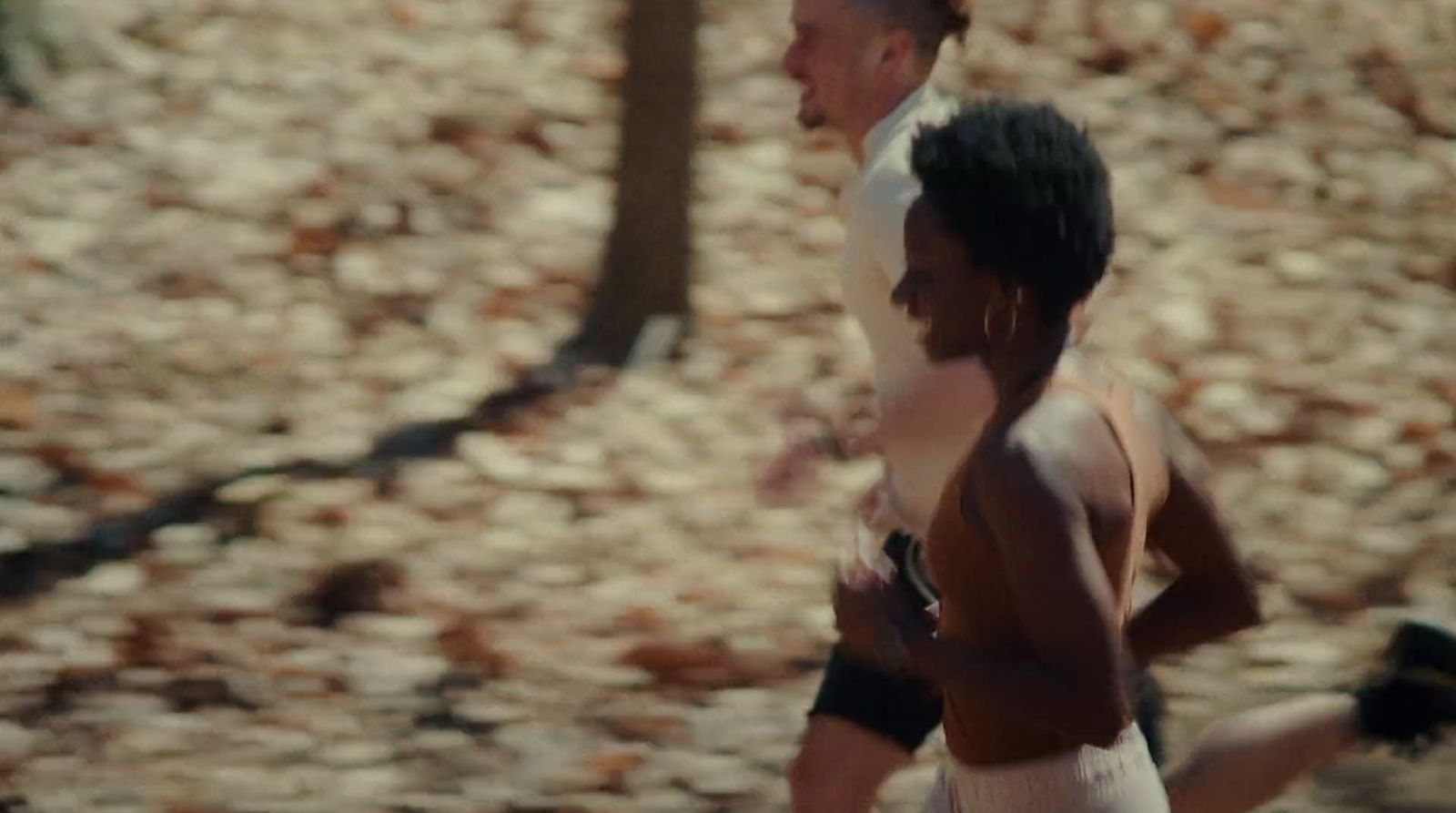 a man and a woman running in the woods