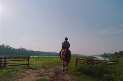 a man riding a horse on a dirt road