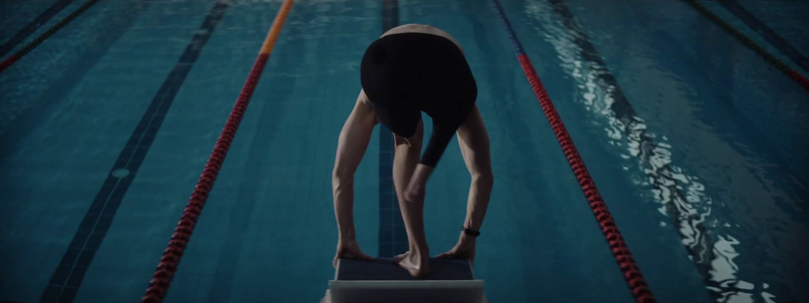 a person standing on a diving board in a pool