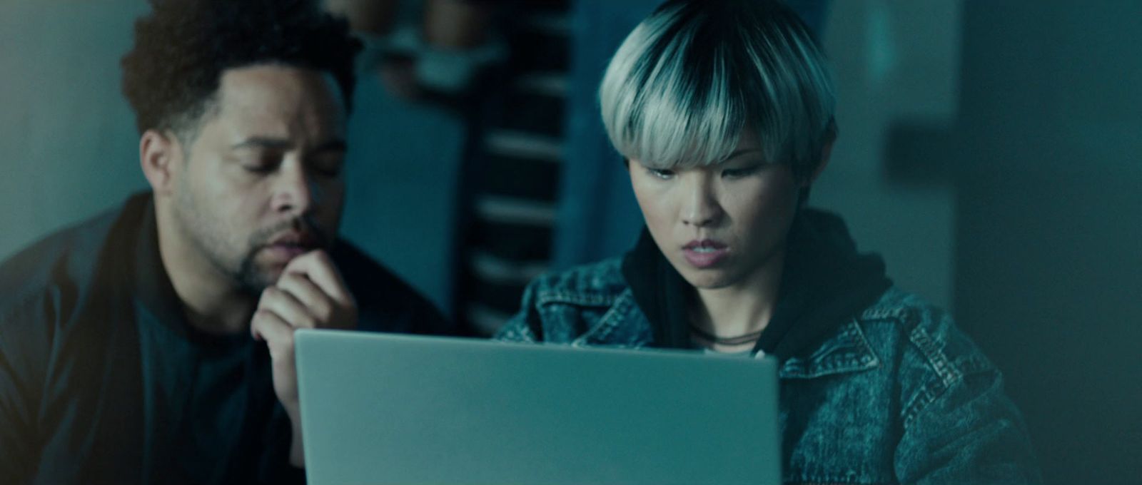 a man and a woman looking at a laptop