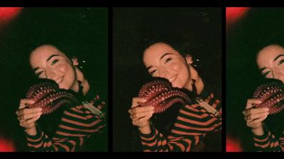 a woman in striped shirt holding an object in front of her face