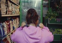 a woman in a pink robe standing in front of a store