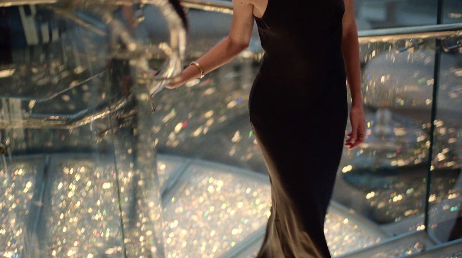 a woman in a black dress walking down a staircase