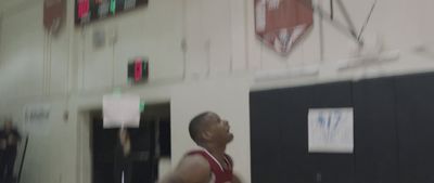 a man in a red jersey is playing basketball