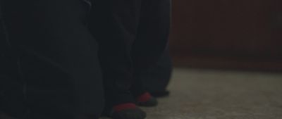 a close up of a person's feet wearing black pants and red socks