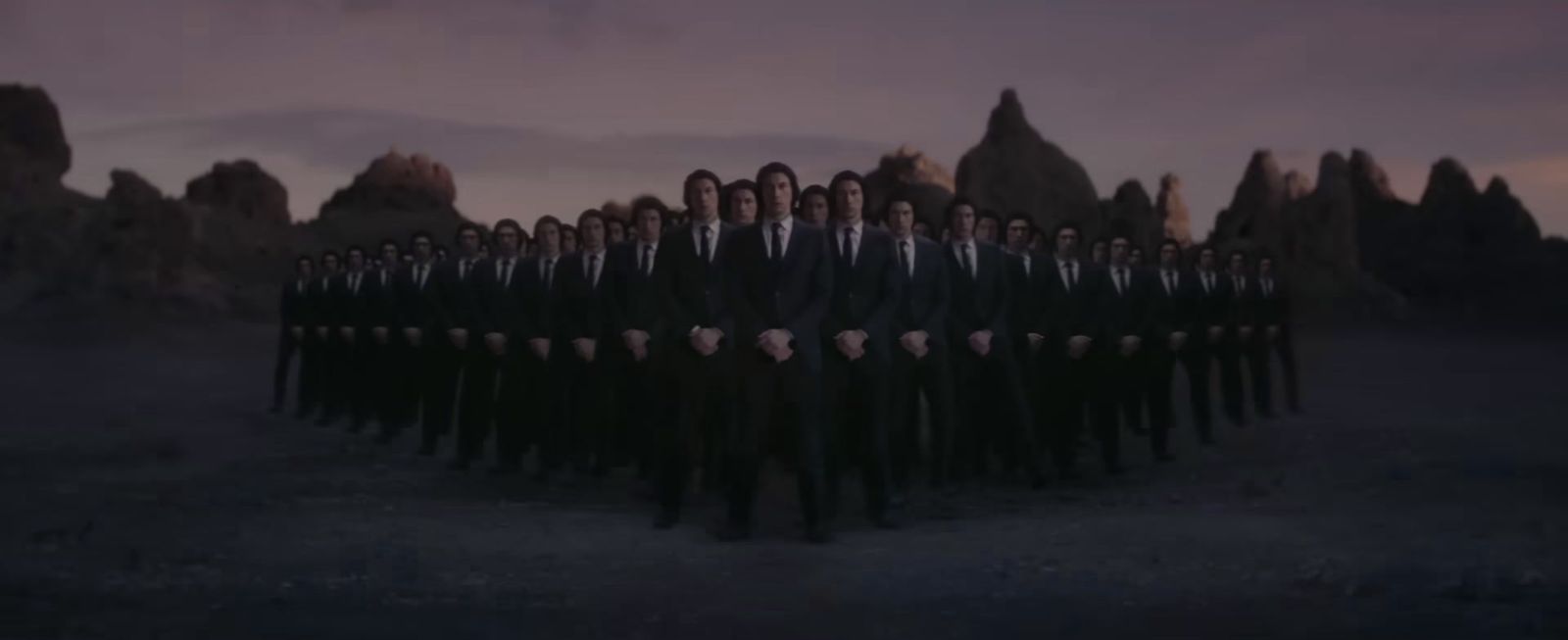 a group of men standing in front of a mountain