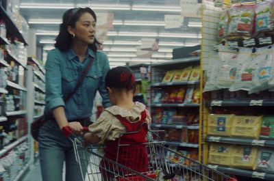 a woman pushing a child in a shopping cart