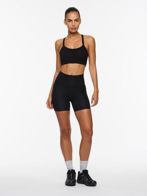 a woman in a black sports bra top and shorts