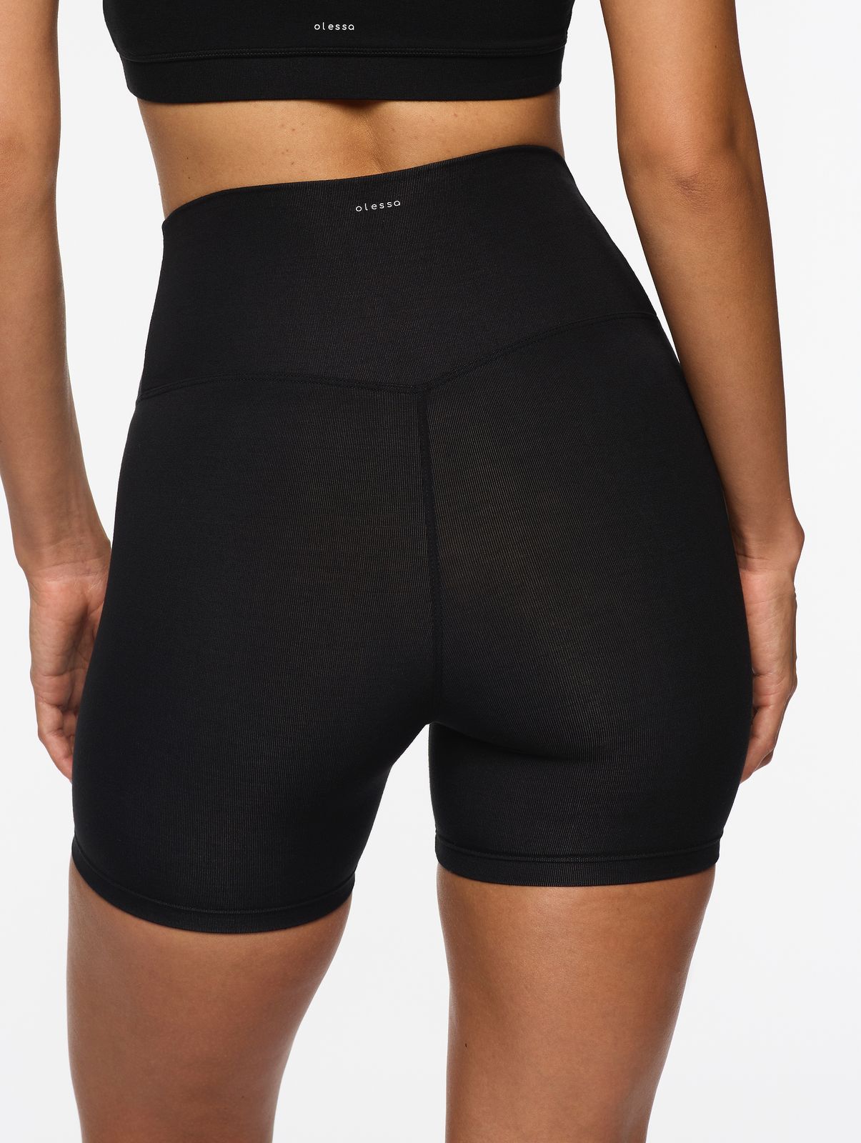 a woman in a black sports bra top and black shorts