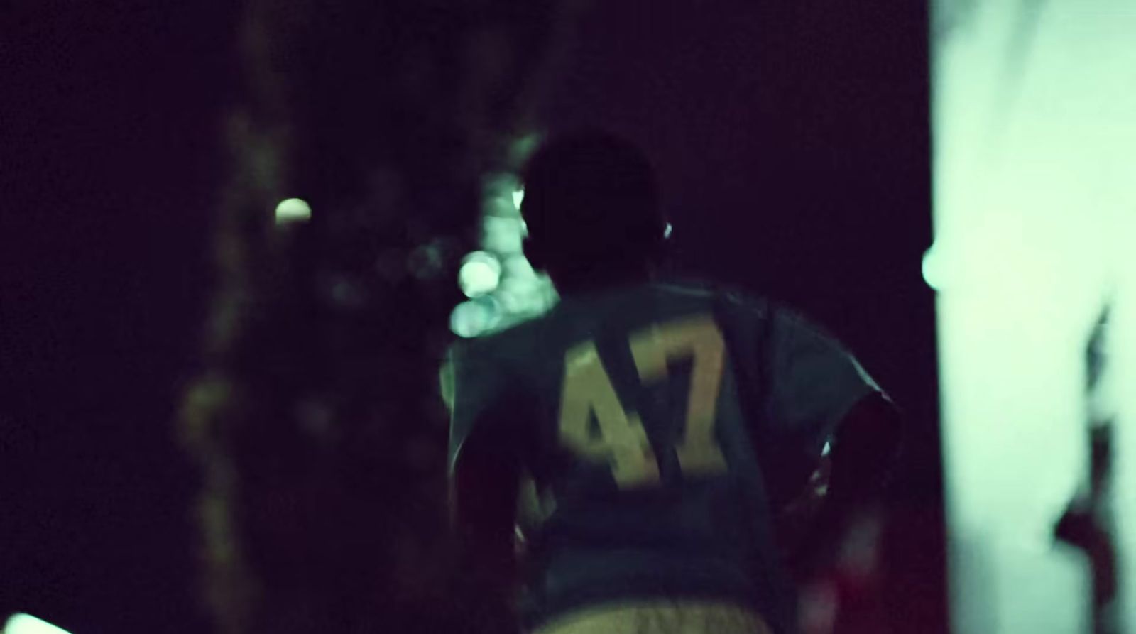 a man standing next to a tree in the dark