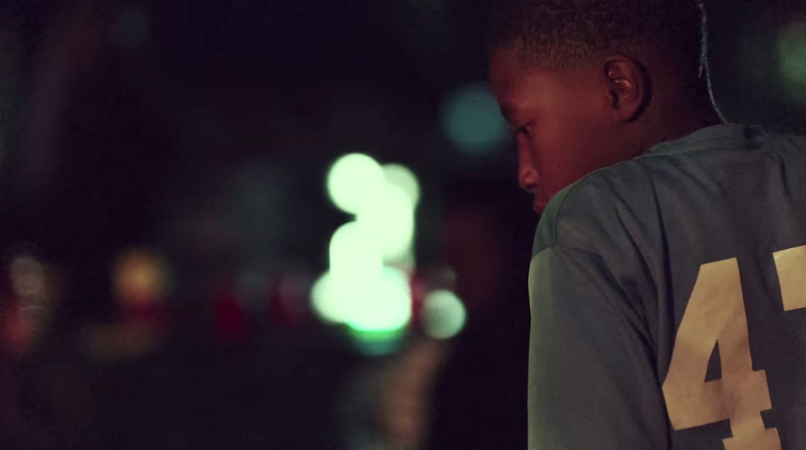 a young boy standing in the street at night