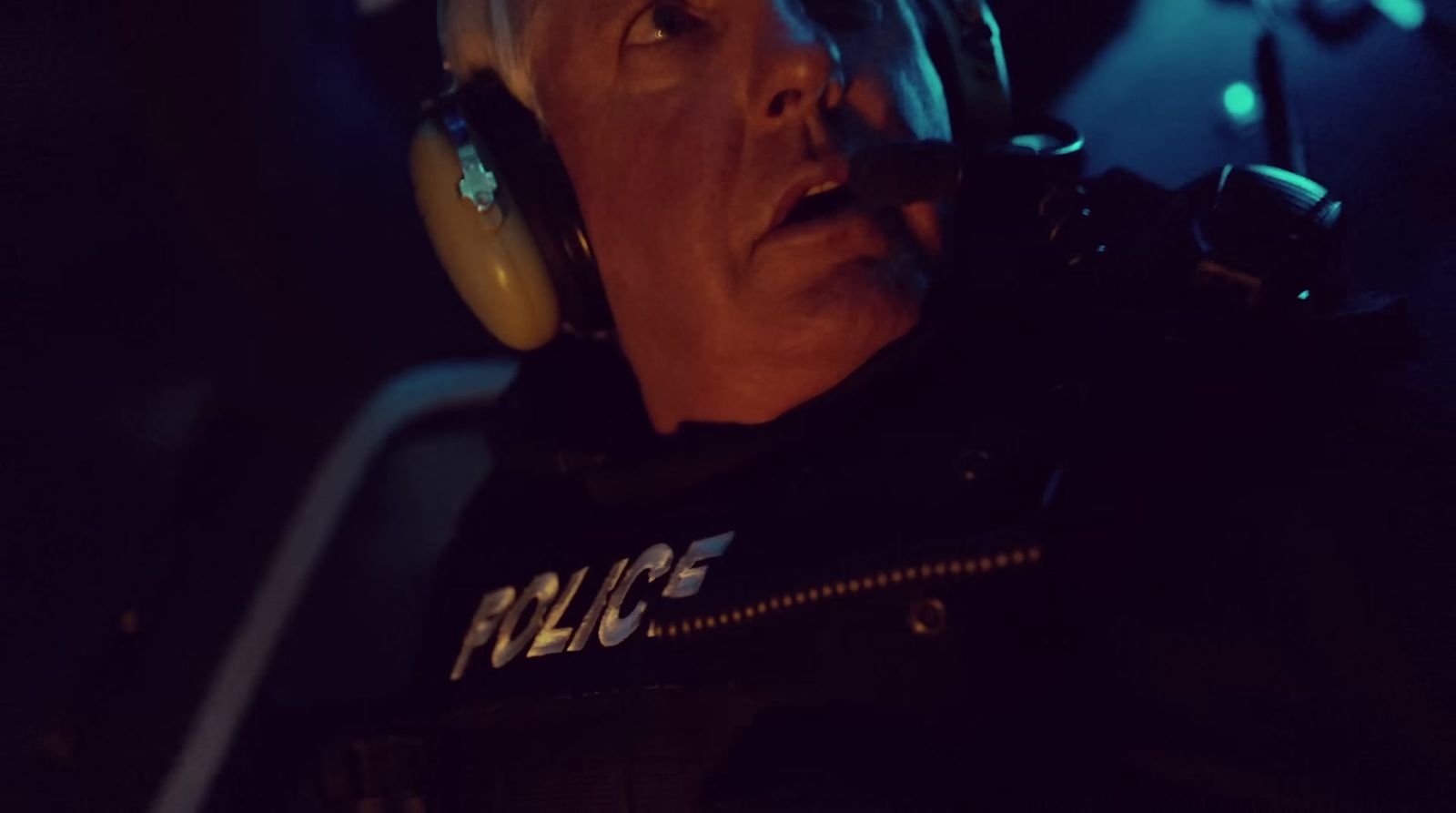 a police officer wearing headphones in a dark room