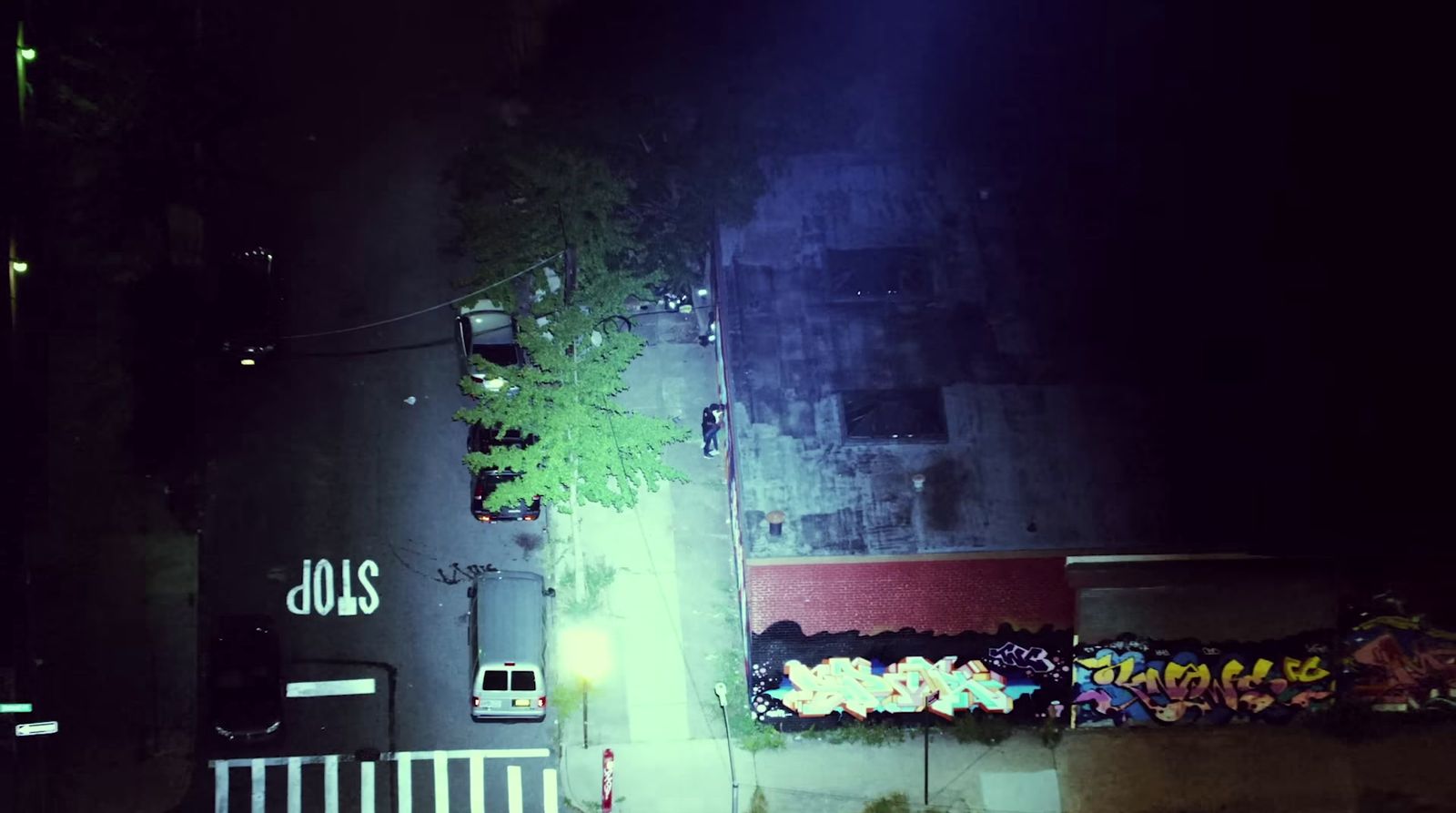 a dark street at night with graffiti on the wall