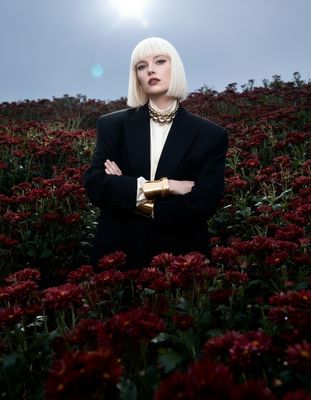 a woman standing in a field of flowers