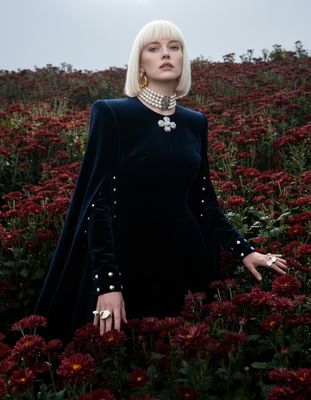 a woman standing in a field of flowers