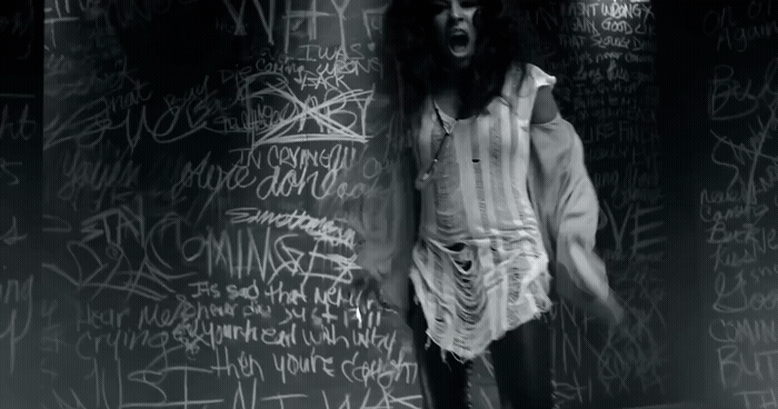 a man standing in front of a wall covered in graffiti