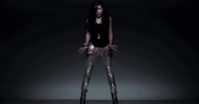 a woman in a black top and gold pants