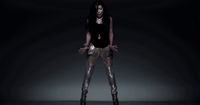 a woman in a black top and gold pants