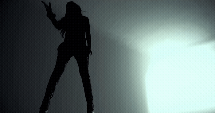 a woman standing in the shadows of a room