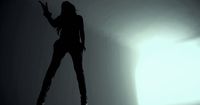 a woman standing in the shadows of a room