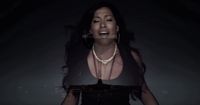 a woman in a black dress with a necklace on
