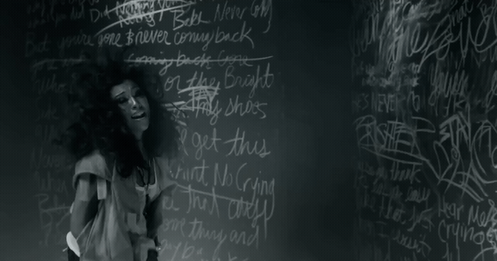 a woman standing in front of a blackboard with writing on it