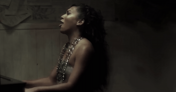 a woman sitting at a piano in a dark room