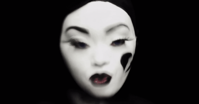 a woman with black and white makeup and white face paint
