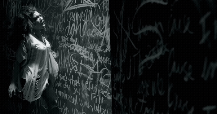 a woman standing in front of a wall covered in graffiti