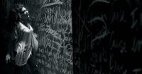 a woman standing in front of a wall covered in graffiti