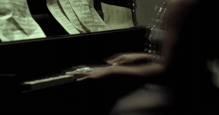 a woman sitting at a piano with sheet music on it