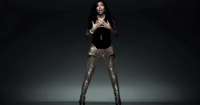 a woman standing in a dark room with her hands together