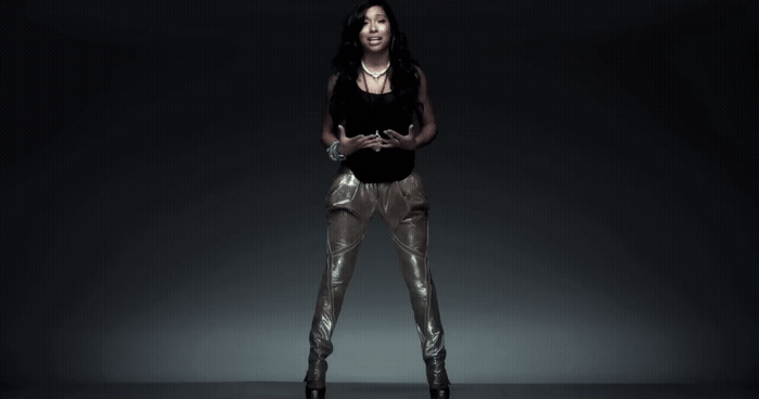 a woman in a black top and gold pants