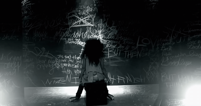 a woman standing in front of a wall covered in graffiti