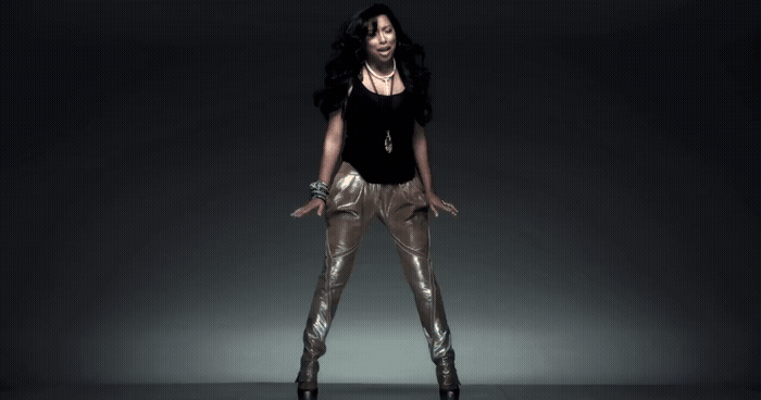 a woman in a black top and gold pants