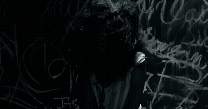 a man standing in front of a wall covered in graffiti