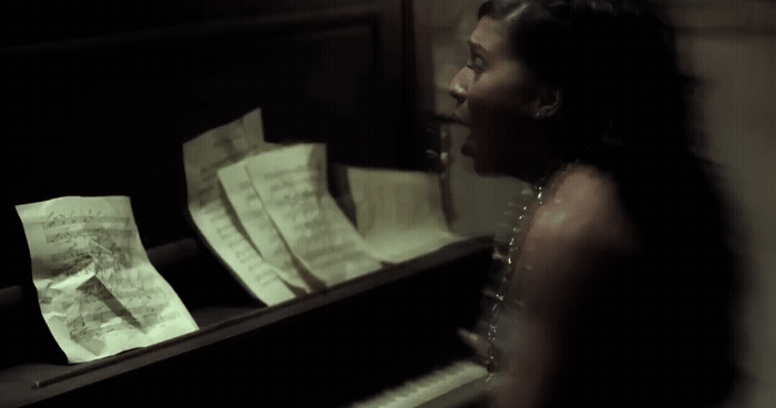 a woman standing next to a piano with sheet music on it