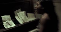 a woman standing next to a piano with sheet music on it