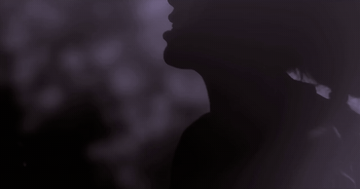 a silhouette of a person with a hat on