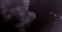 a silhouette of a person with a hat on