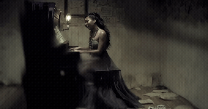 a woman sitting at a piano in a dark room